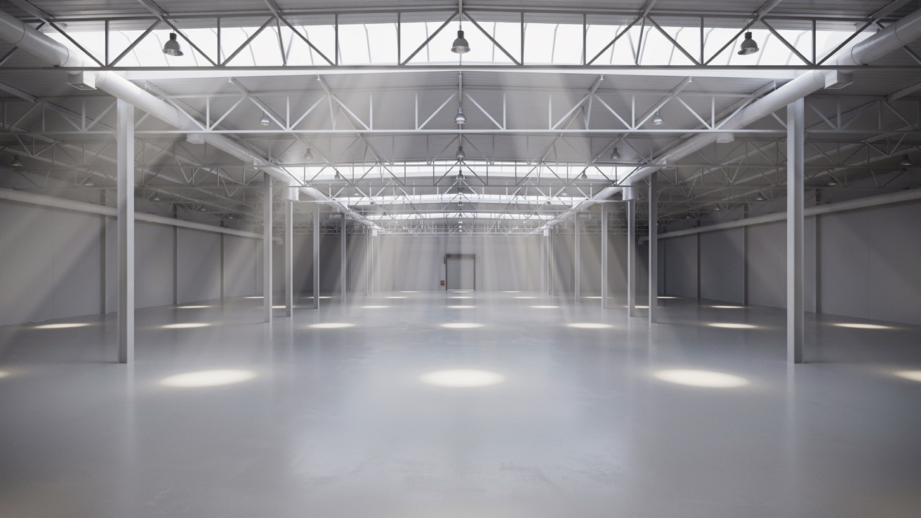 Interior de nave industrial iluminada con luz natural a través de lucernarios y domos en la cubierta